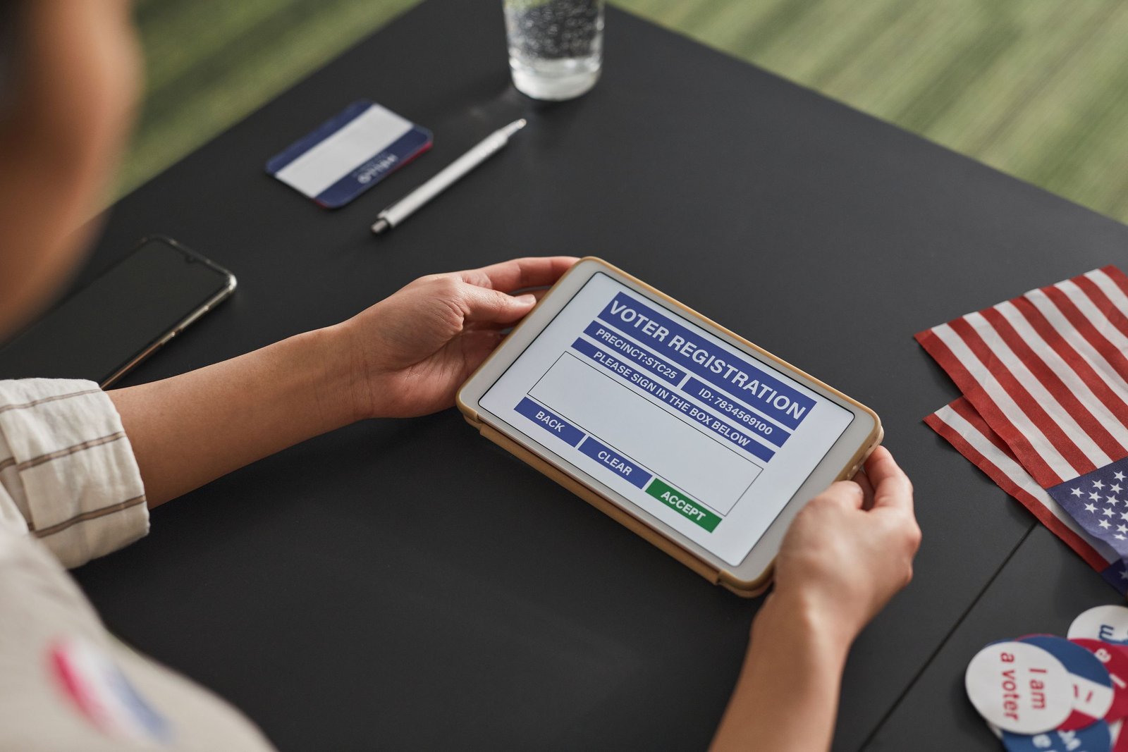 service-1-1 A person using a tablet for voter registration, highlighting digital voting processes.