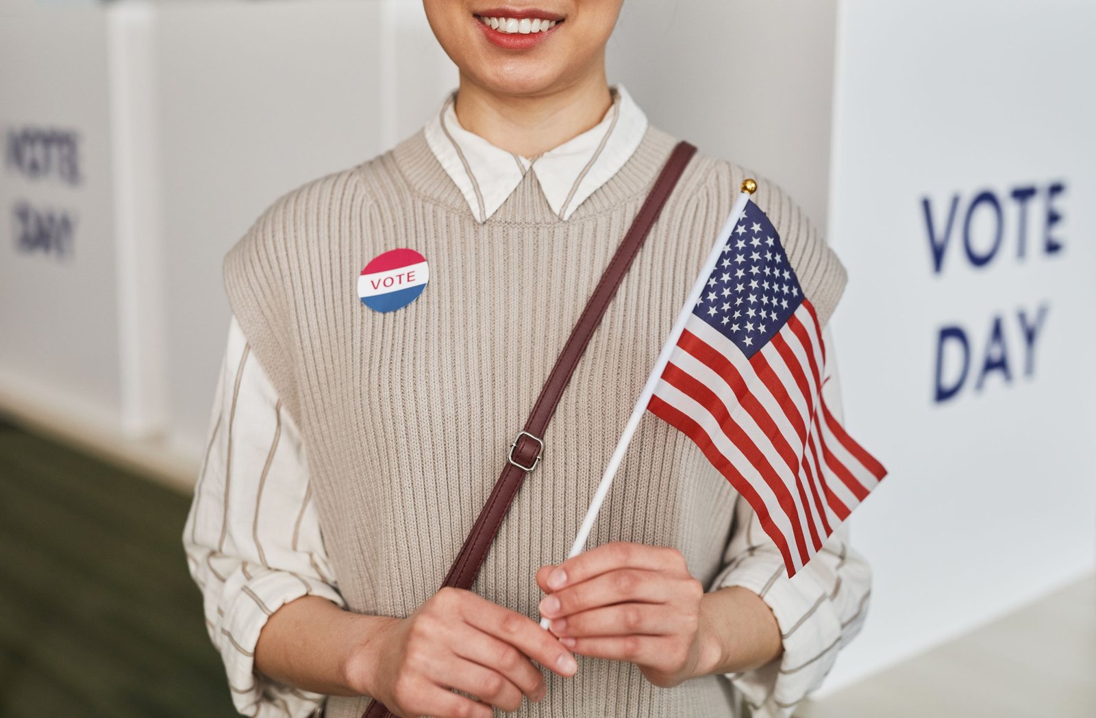 service-1-1 A woman proudly holds the American flag and smiles, celebrating voting day.